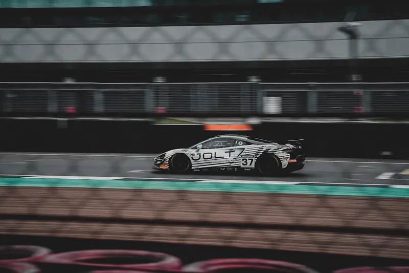 A race car speeds around a racetrack.